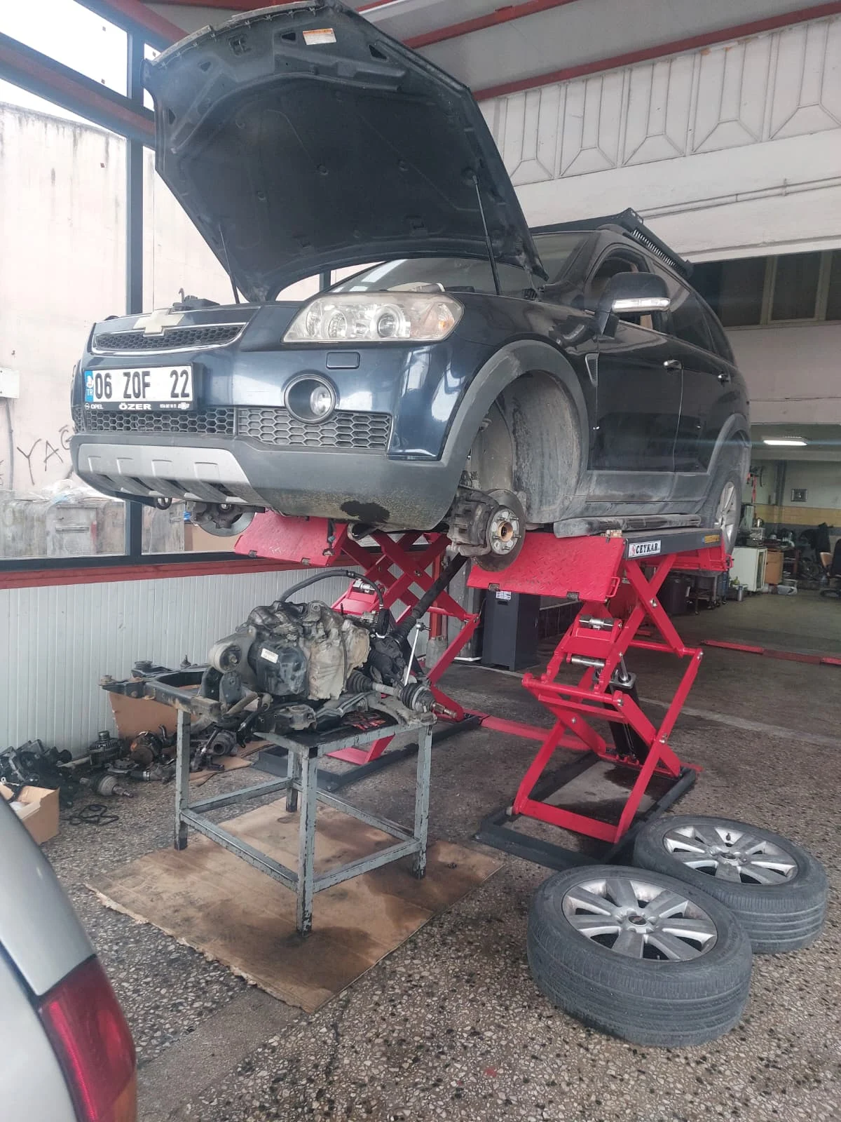 Atölyede lifte alınmış Opel araç ve mekanik onarım alanı